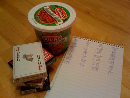 Cards and Scorepad for Nertz, with a Container of Salsa. Final Scores: S: 165, T: 94, A: 290, D: 99
