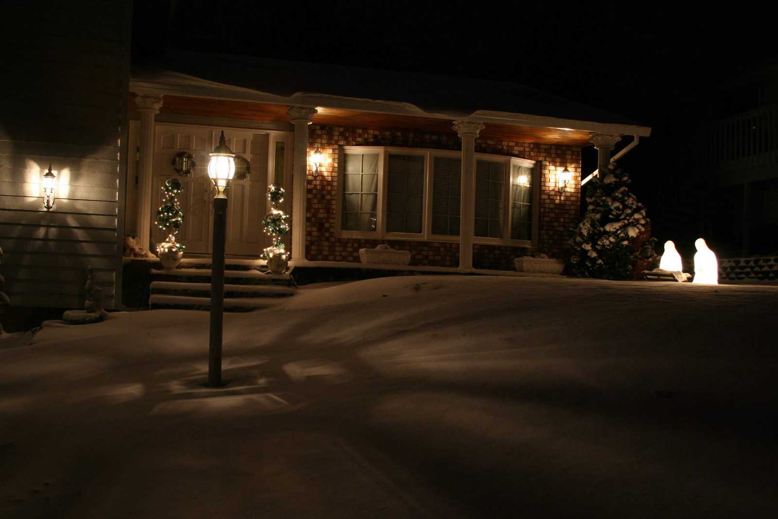 View of a house lit up for Christmas in the snow after dark